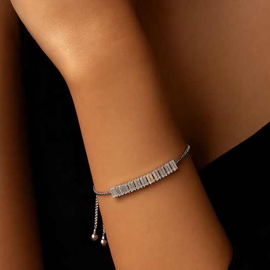 Silver bracelet on a wrist against a dark background
