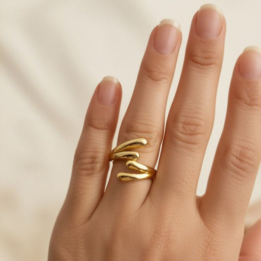 Gold ring on a hand against a neutral background