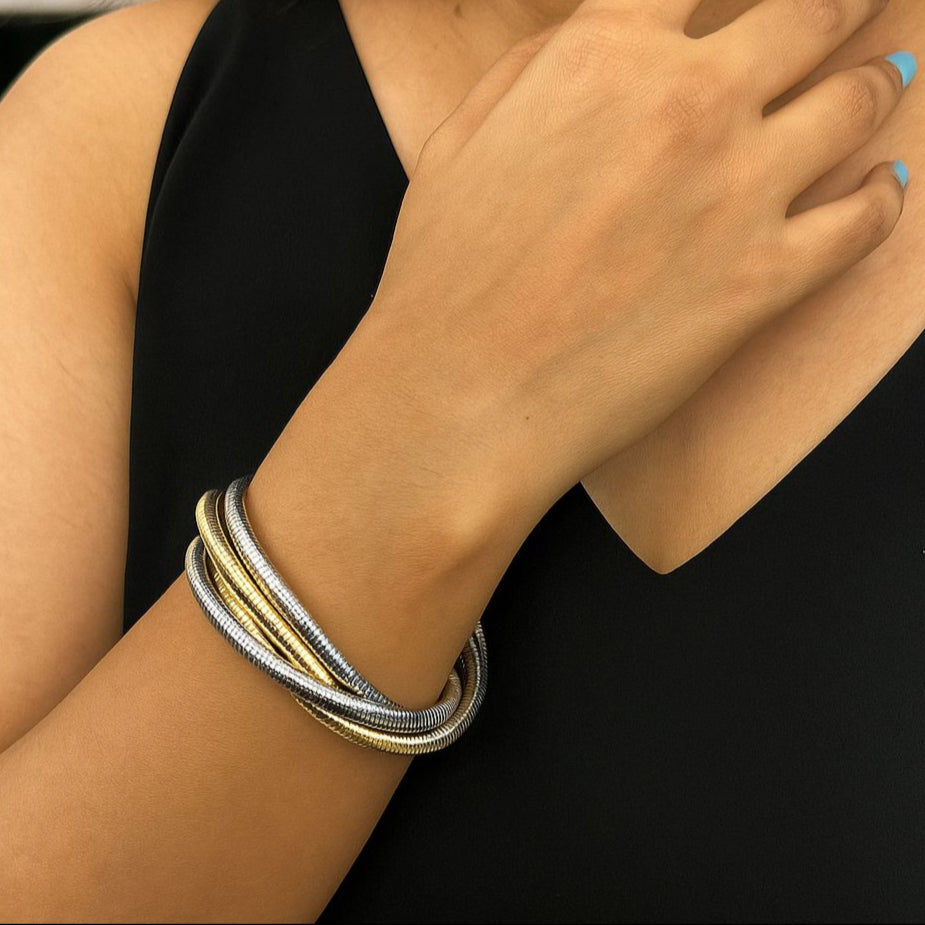 Close-up of a person wearing multiple bracelets on their wrist with a blurred background