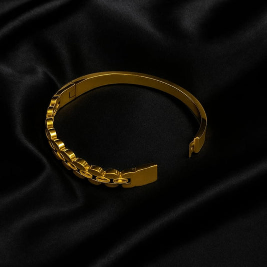 Gold bracelet on a black satin background