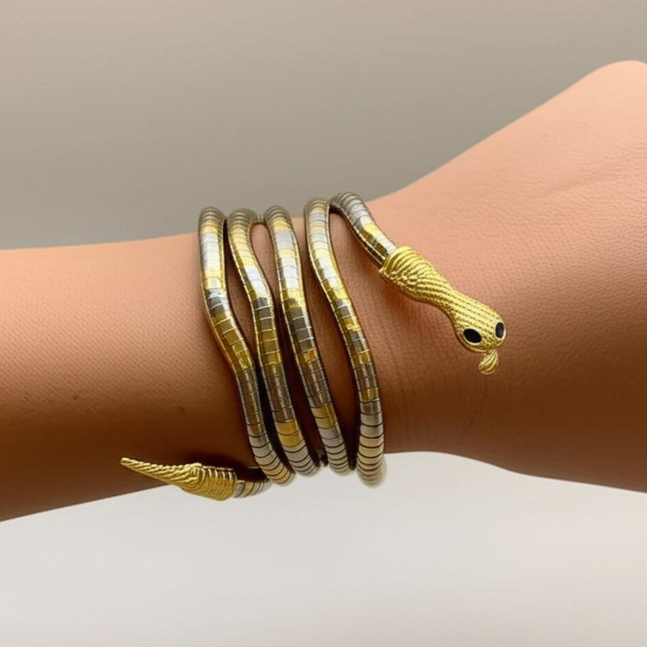 Gold snake-shaped bracelet on a wrist against a neutral background