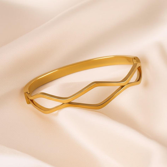 Gold bracelet on a beige fabric background