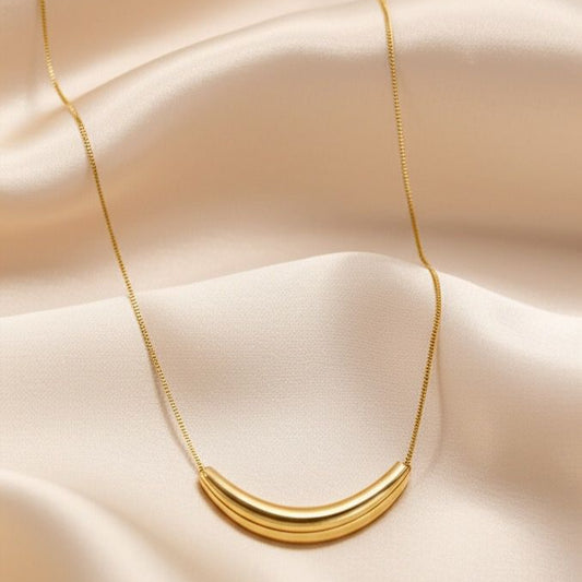 Gold necklace on a beige fabric background