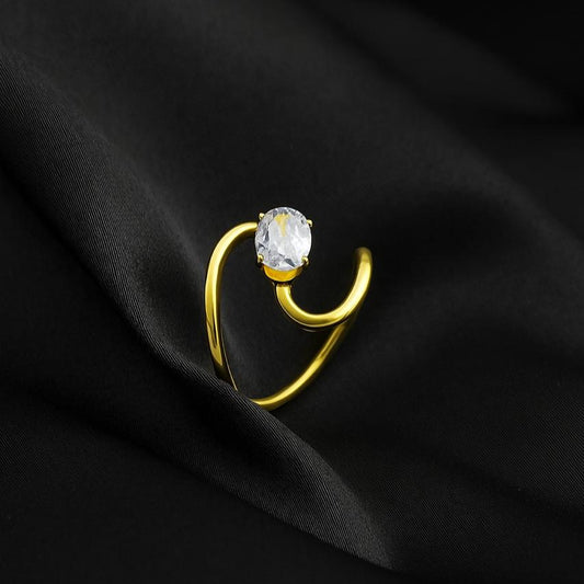 Gold ring with a diamond on a black fabric background